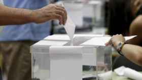 Imagen de archivo de una persona depositando su voto en una urna.