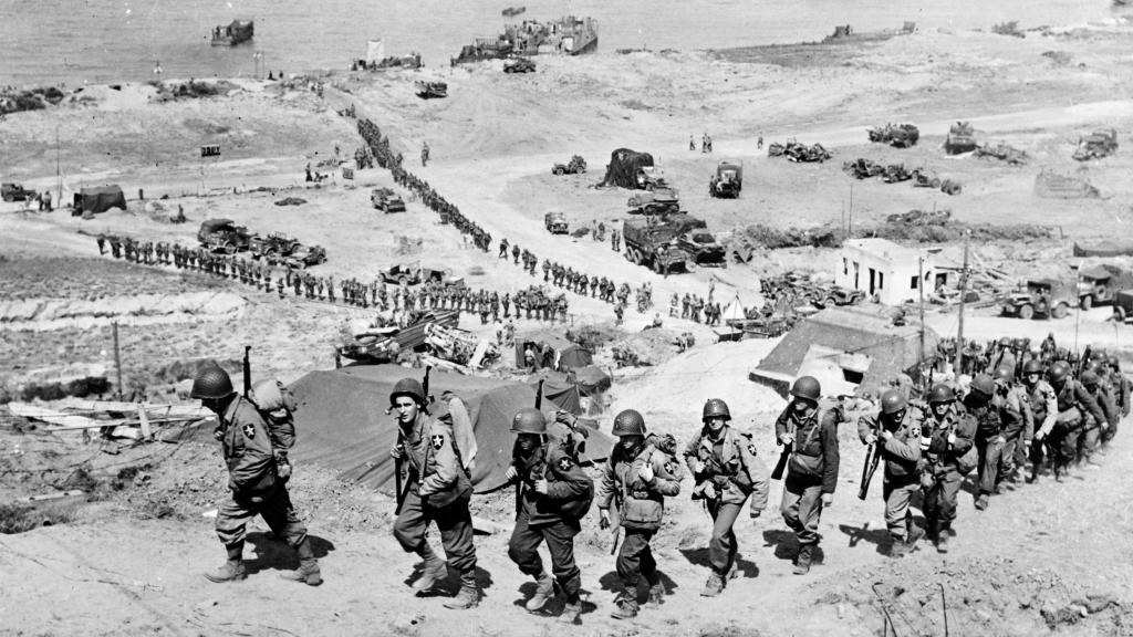 Tropas estadounidenses tras desembarcar en Normandía pasan al lado de un búnker alemán.