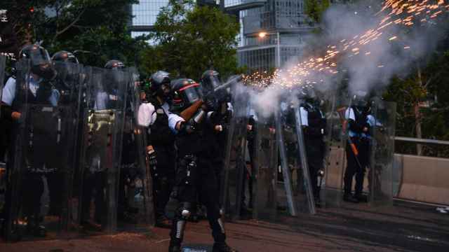 Policías hongkoneses disparan gases lacrimógenos contra protestantes.