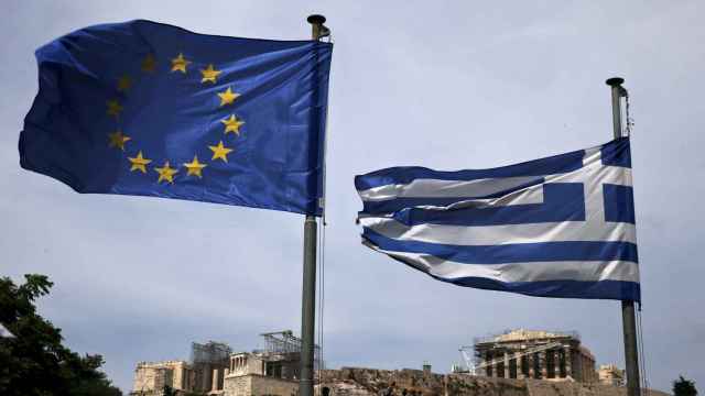 Las banderas de Grecia y la UE ondean el Partenón de fondo.
