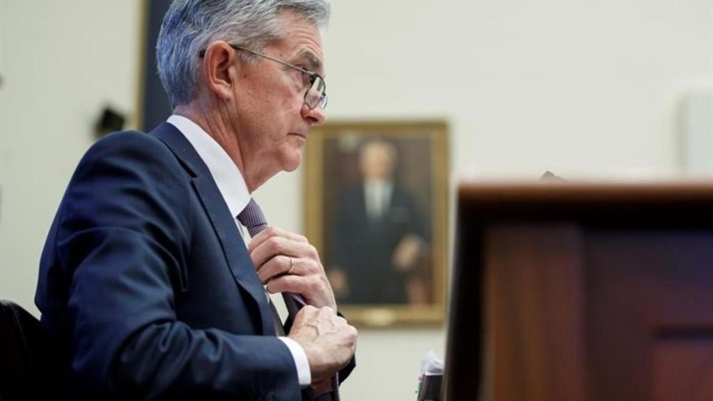 El presidente de la Fed, Jerome Powell, se ajusta la corbata en una comparecencia.