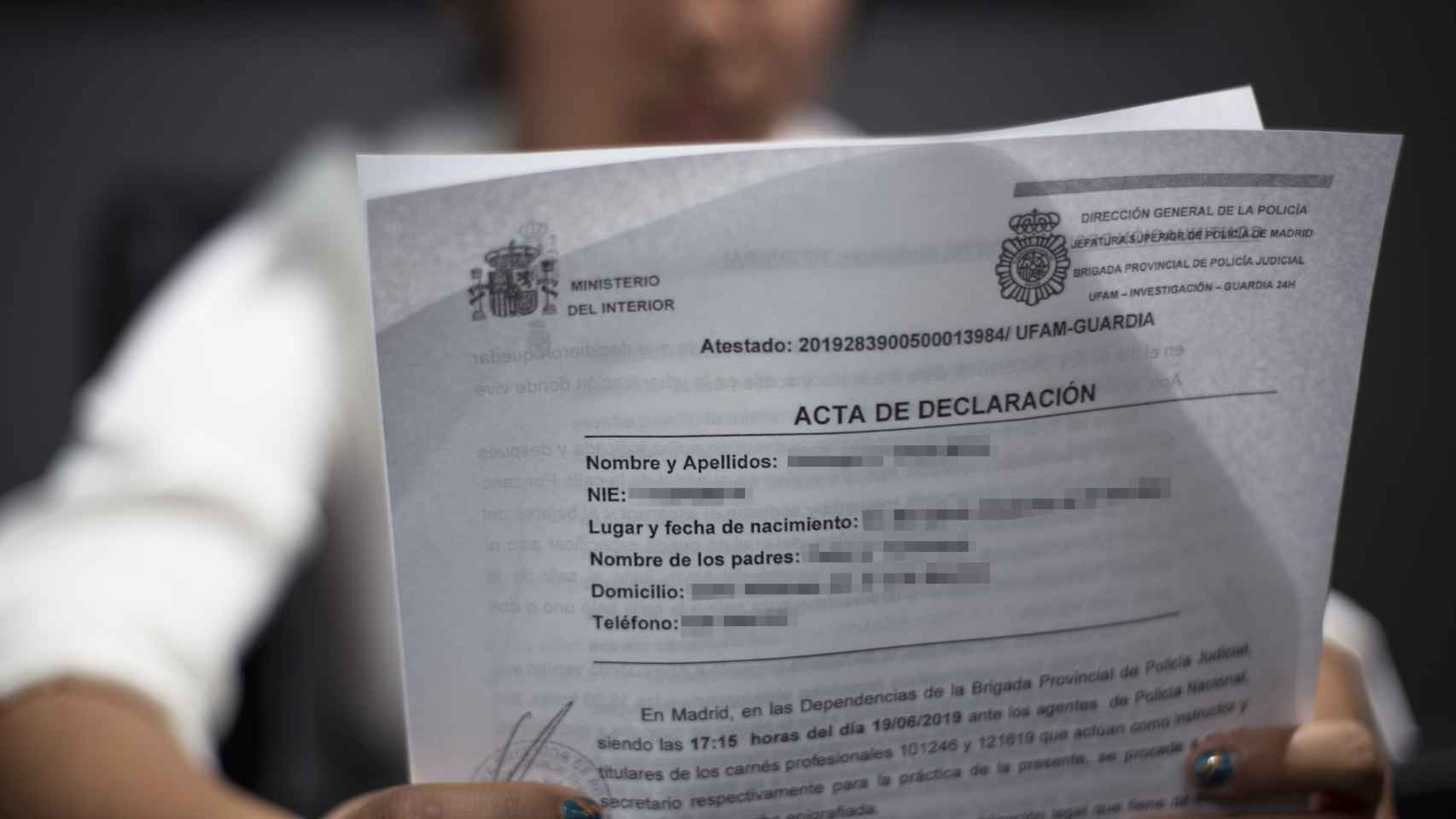 La víctima muestra la denuncia que presentó tras los hechos en una comisaría de Madrid.