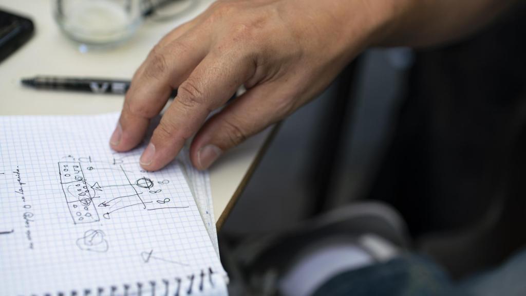 Santiago explicando en una libreta el plan de uno de los simulacros.