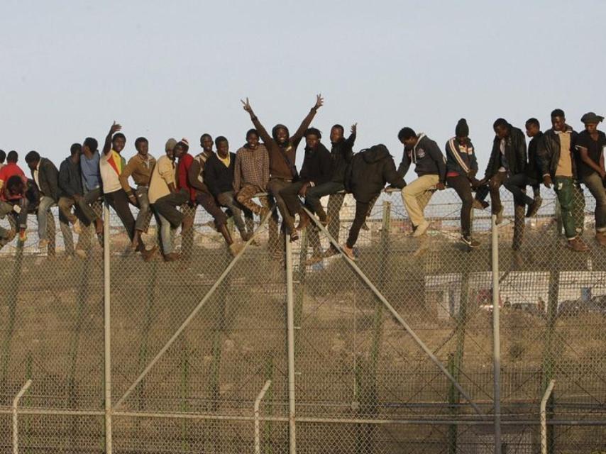 Inmigrantes encaramados a la valla fronteriza de Melilla.