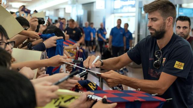 Piqué firmando autógrafos en la llegada a Japón