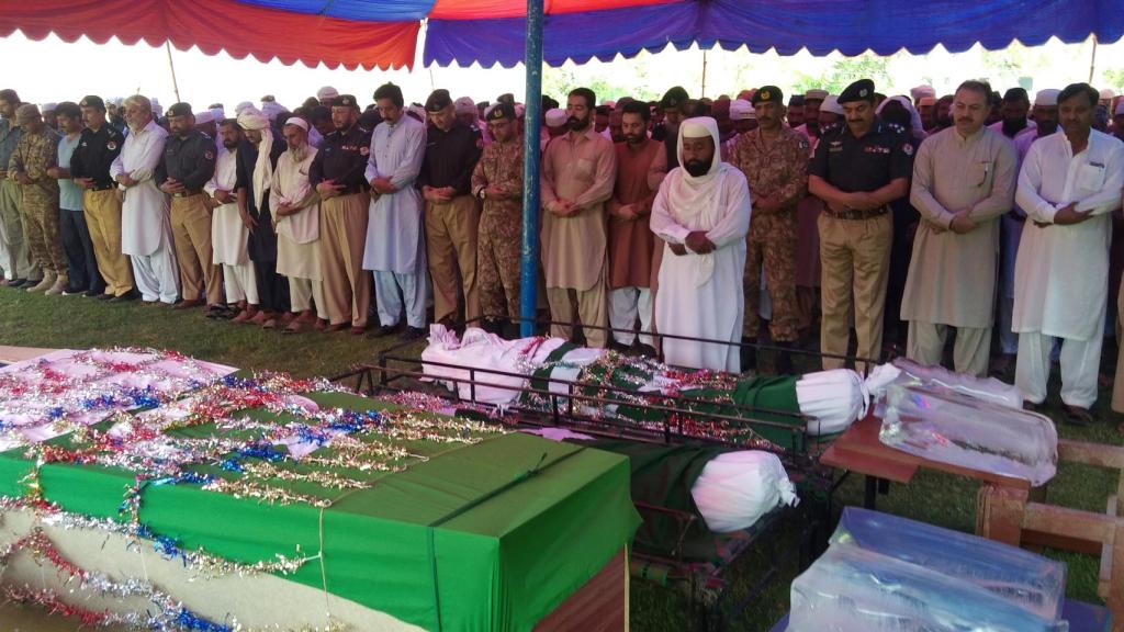 Poilicáis, soldados y allegados a las víctimas rezan ante sus cuerpos en Dera Ismail Khan (Pakistán).