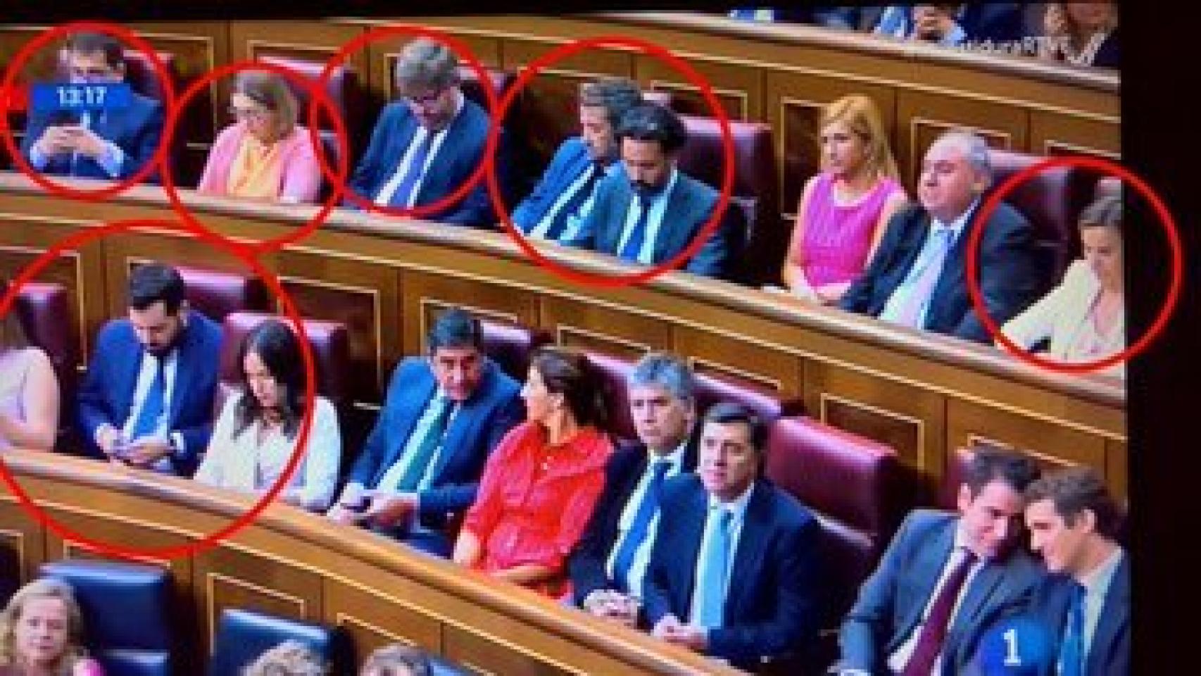 Uno de los planos en los que se ve a varios diputados atentos a sus móviles