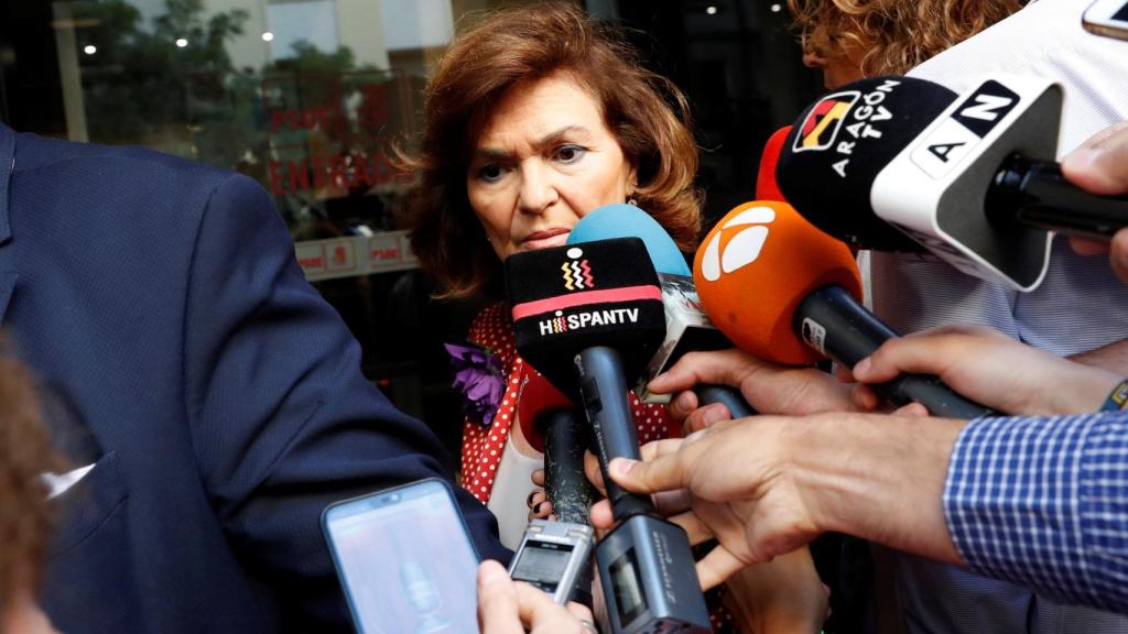 Carmen Calvo, antes de la investidura, con una chaqueta roja y una flor morada.