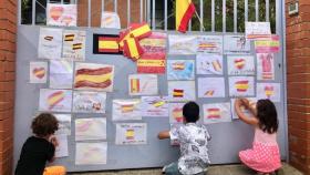 La puerta del colegio se llenó de banderas de España en apoyo a la niña.
