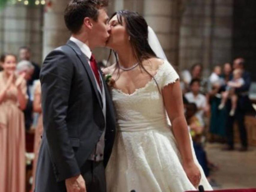 Detalle del beso de los novios ante la atenta mirada de los invitados.