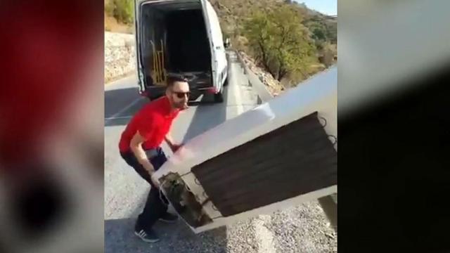 El joven arrojando el frigorífico al vacío