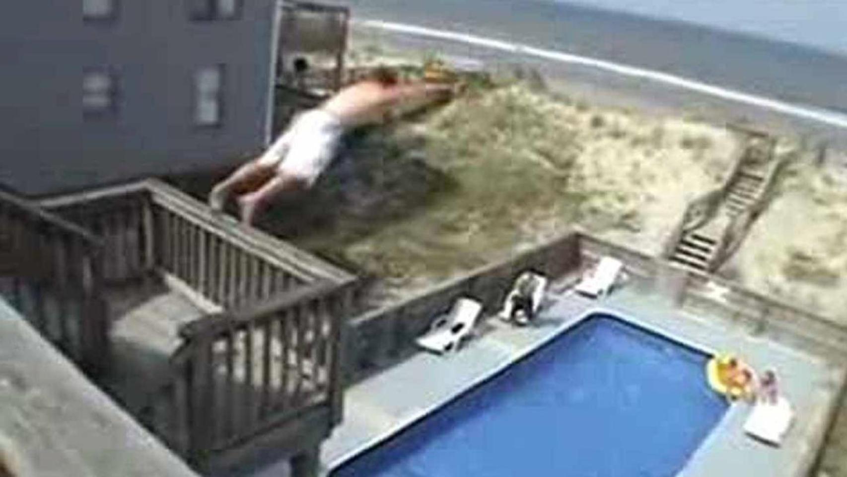 Un hombre lanzándose a la piscina mientras hace 'balconing'
