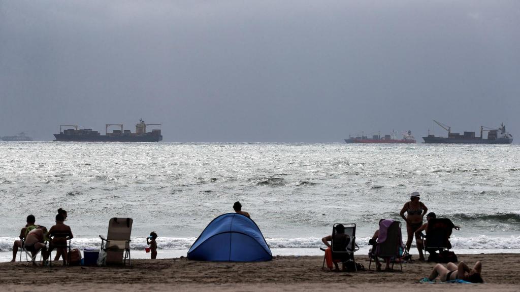 Varios personas disfrutan de un día de playa en Pinedo de Valéncia.