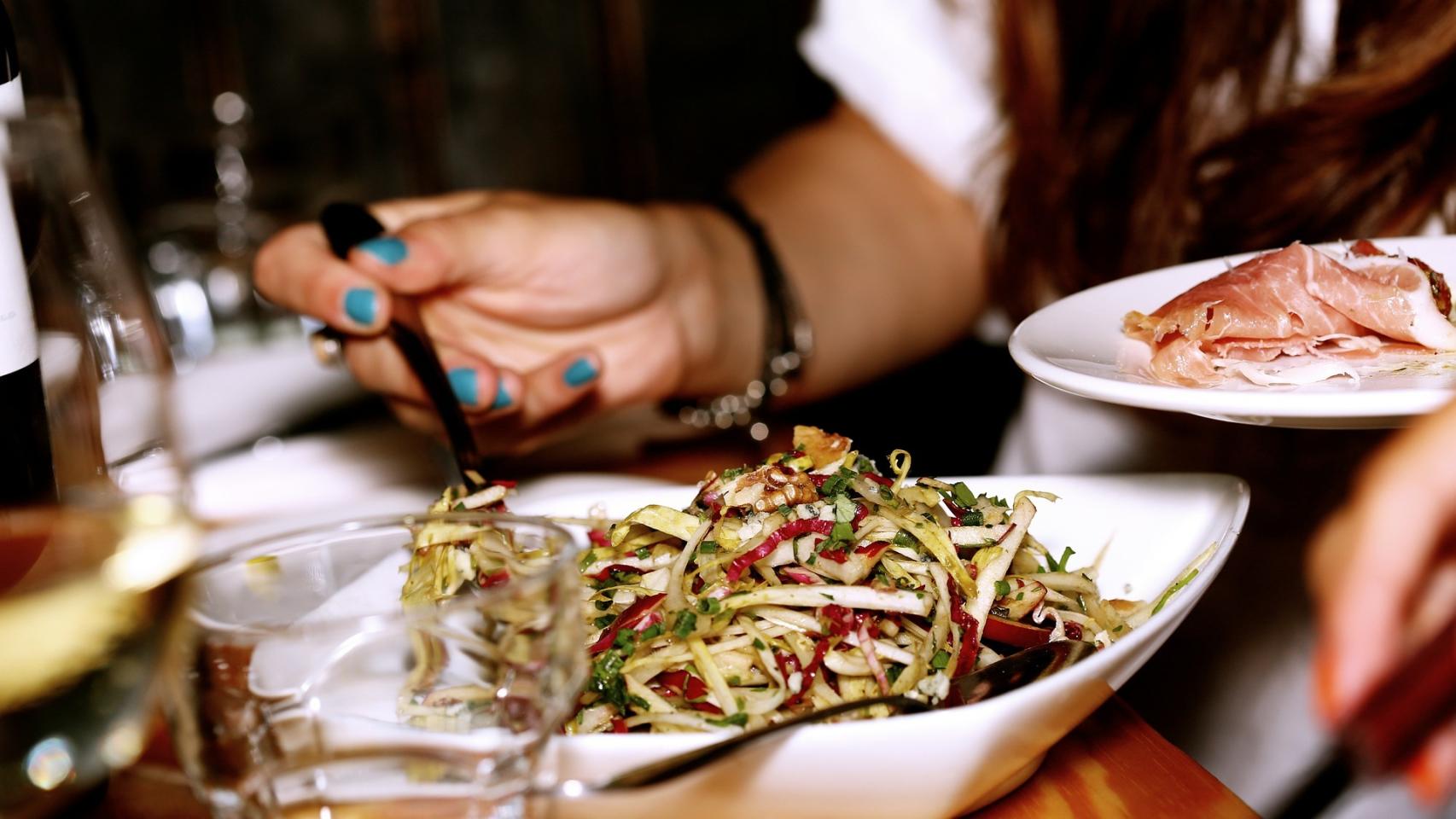 Una mujer cenando en un restaurante.