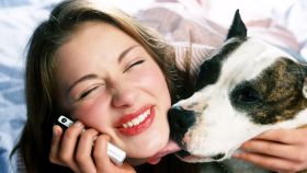 Una mujer recibe un cariñoso lametazo de su perro.