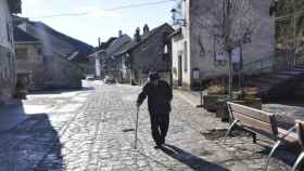 Un anciano pasea por un pueblo