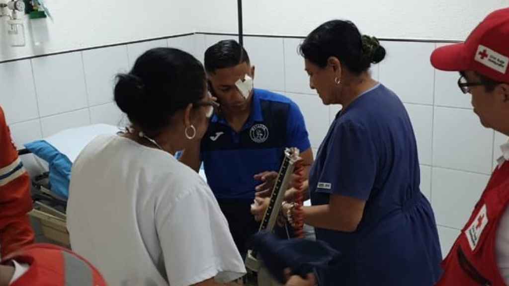 Un jugador del Motagua es atendido tras el vandálico ataque al autobús del equipo. Foto: Twitter (@MOTAGUAcom)