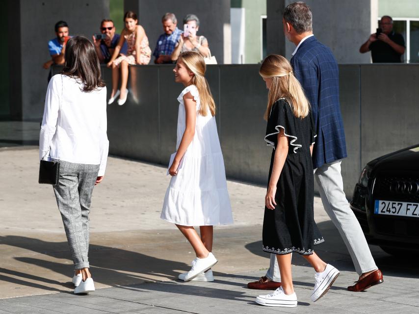 Felipe y Letizia, junto a sus hijas, entrando en el hospital tras hablar con los medios.