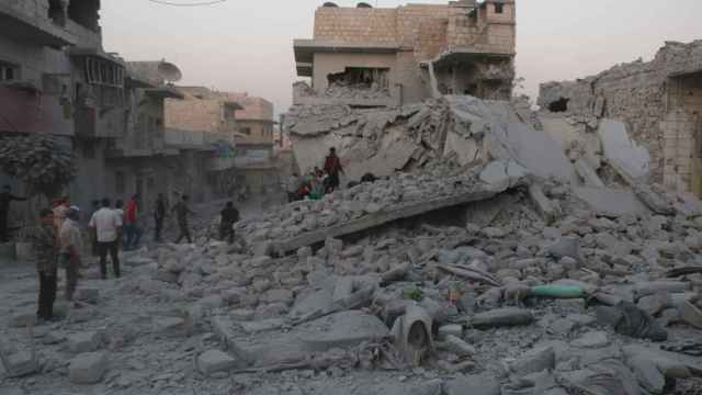Un grupo de personas inspecciona los edificios dañados en Maarat al-Numan, provincia de Idlib.