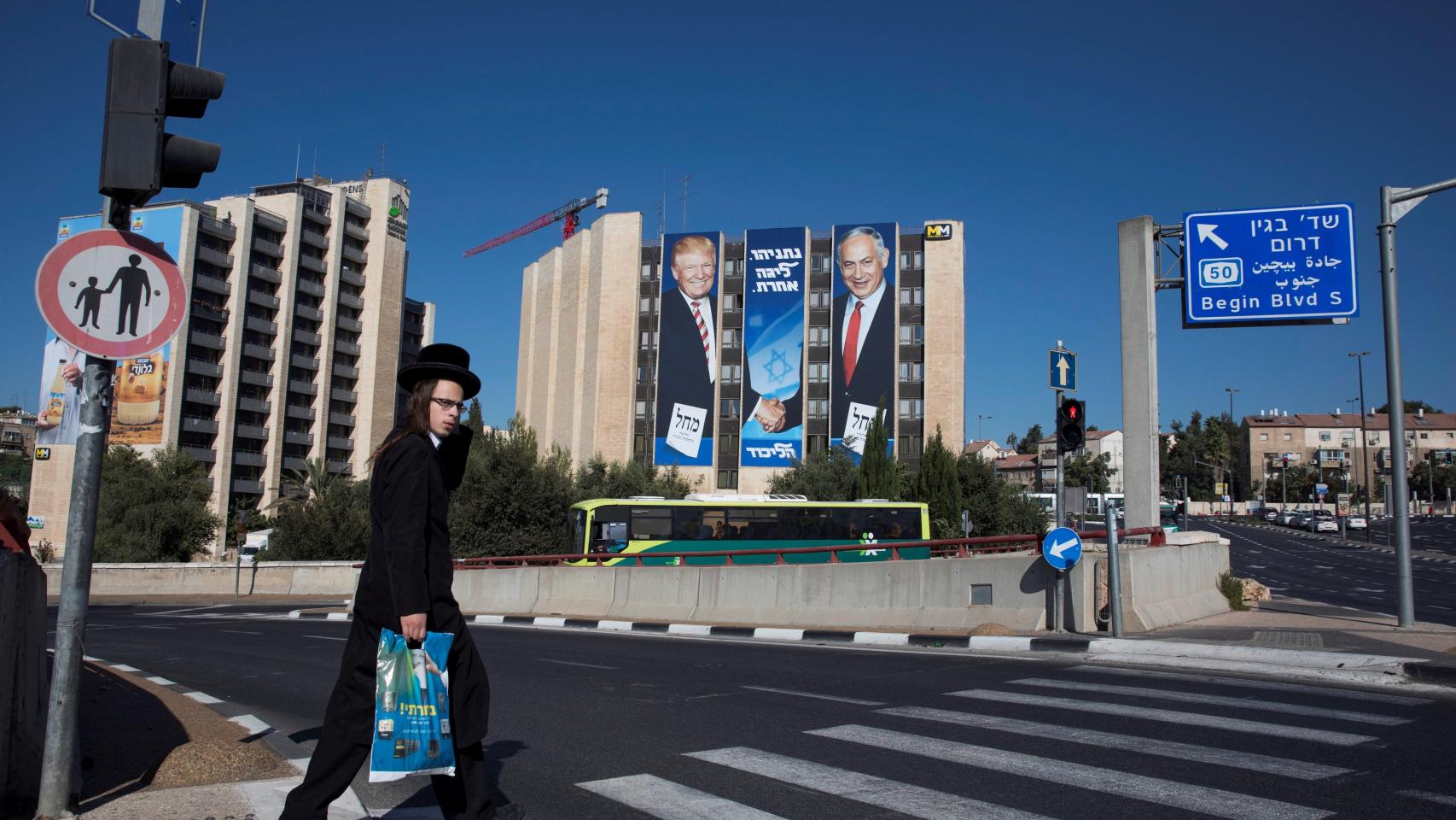 Un hombre pasa junto a una valla publicitaria de la campaña de Likud.