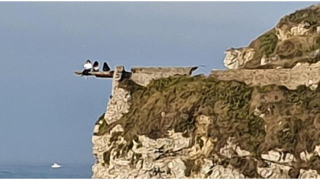 Las tres adolescentes en el saliente del cerro Santa Catalina, en Gijón.