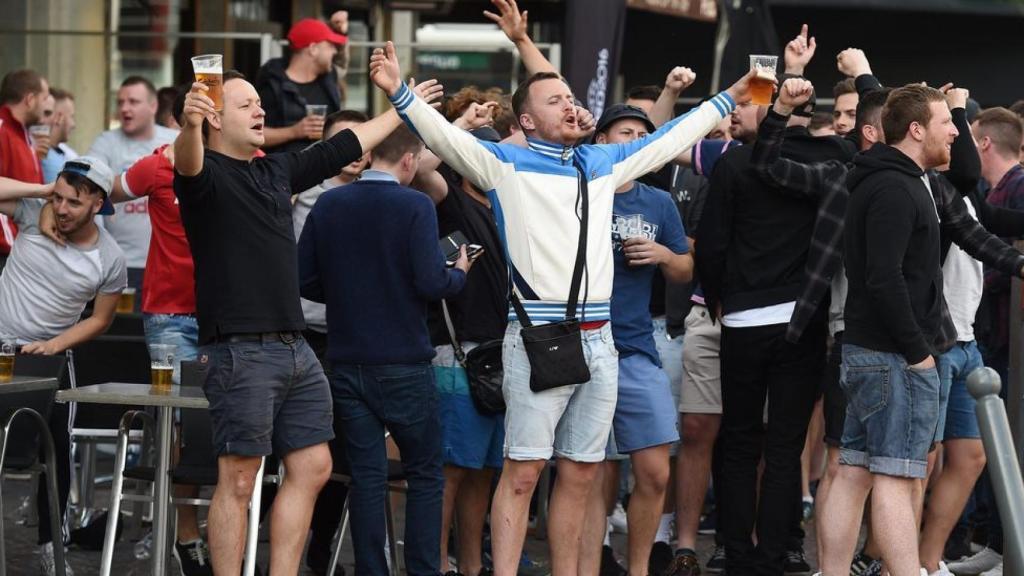 Aficionados ingleses cantando y bebiendo cerveza