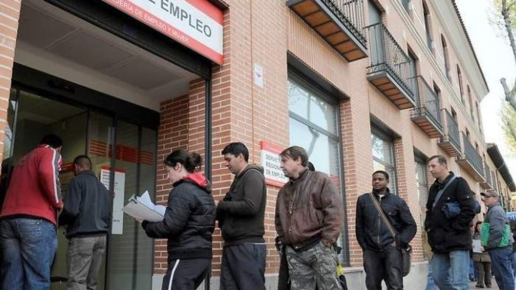 Gente esperando en la puerta de la oficina de empleo.