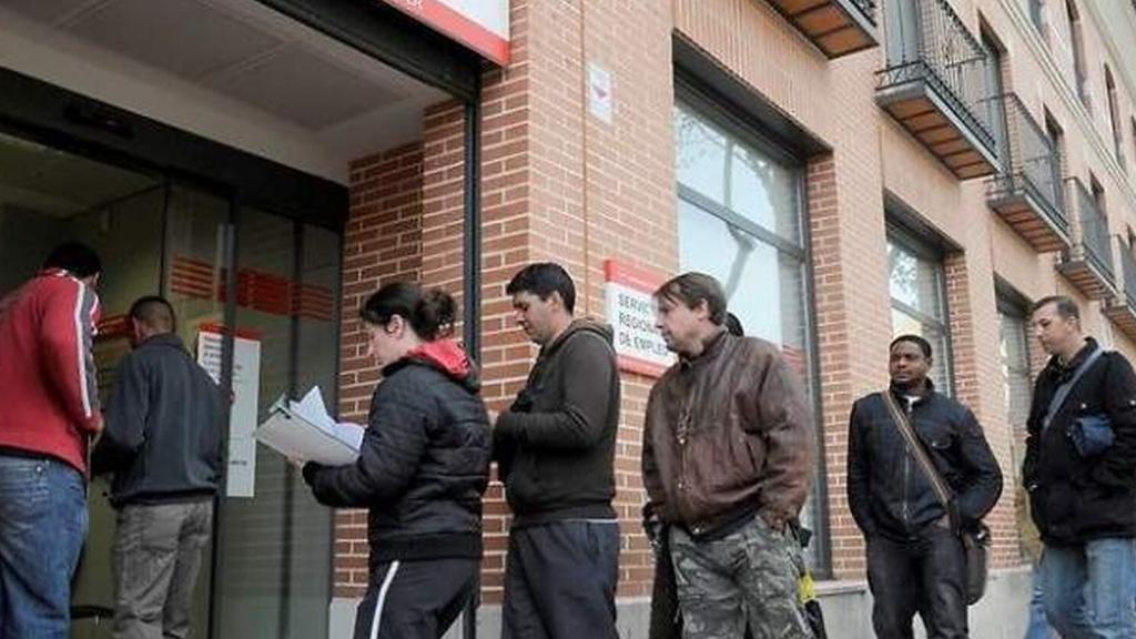 Gente esperando en la puerta de la oficina de empleo.