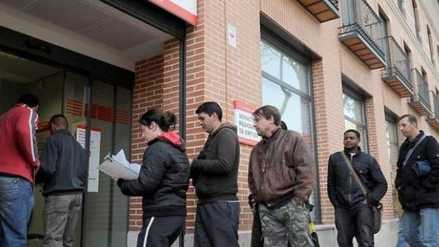 Gente esperando en la puerta de la oficina de empleo.