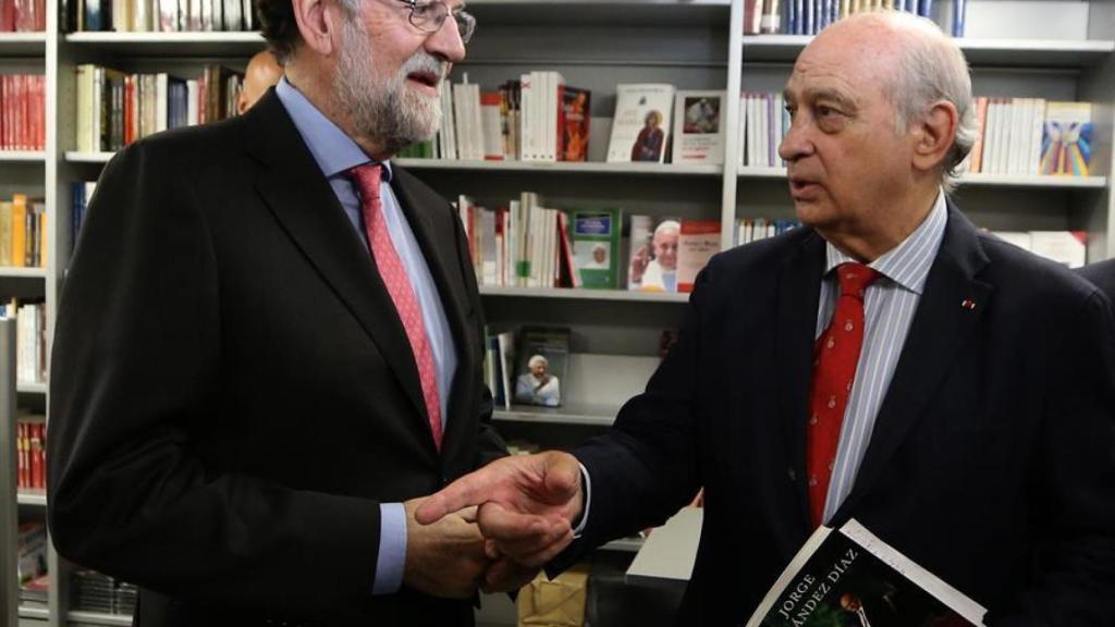 El expresidente del Gobierno Mariano Rajoy conversa con el exministro del Interior Jorge Fernández Díaz durante la presentación de su libro.