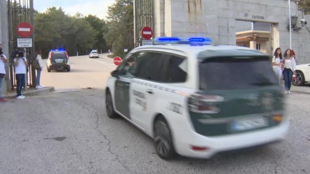 Coches de la Guardia Civil entran a toda velocidad en el Valle de los Caídos con las sirenas en marcha.