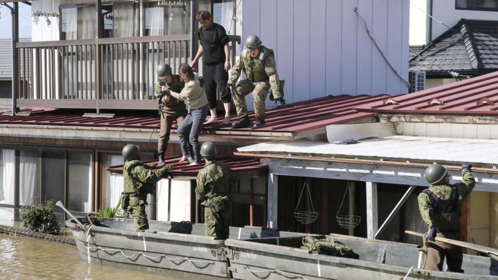 Miembros de los equipos de rescate ayudan a desalojar las viviendas.