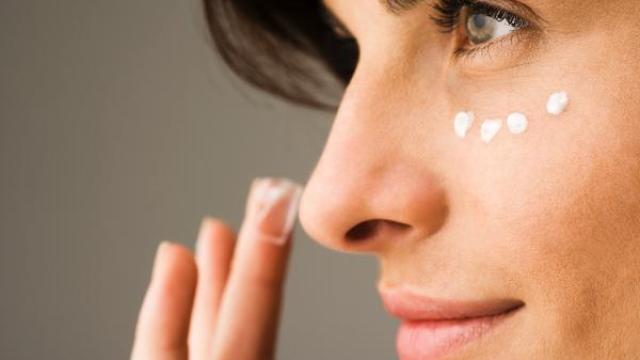 Una mujer se aplica crema en la cara.