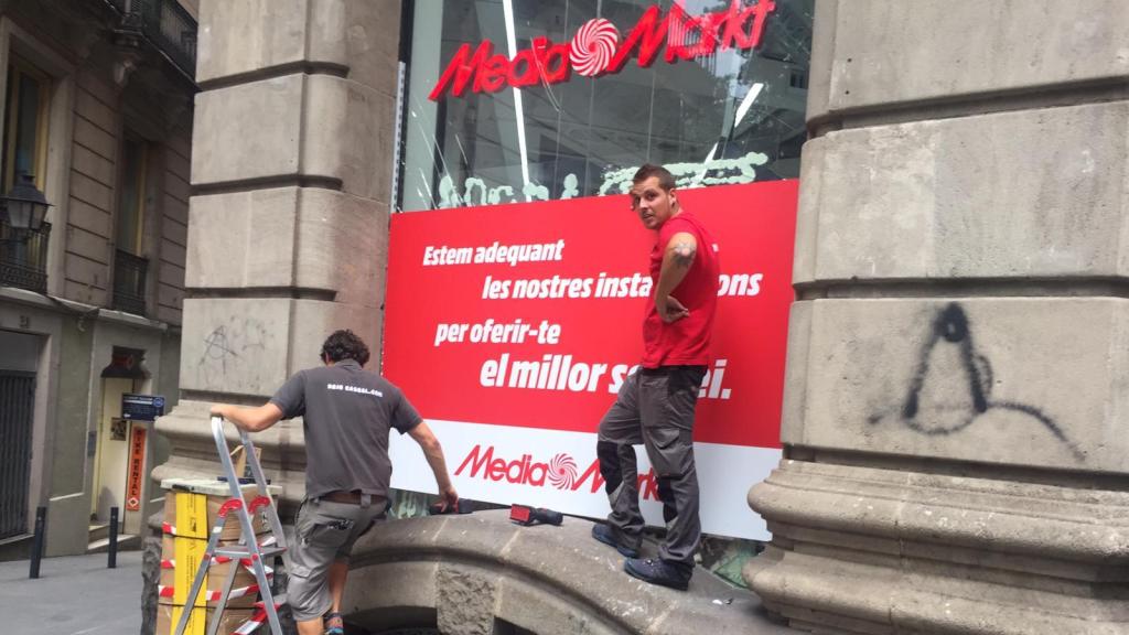 Trabajadores de Media Markt reparan el escaparate tras unas algaradas en Barcelona