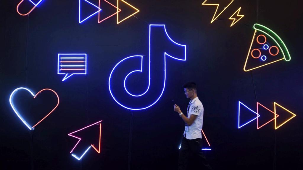 Man walks past a sign of ByteDance's app TikTok, known locally as Douyin, at an expo in Hangzhou