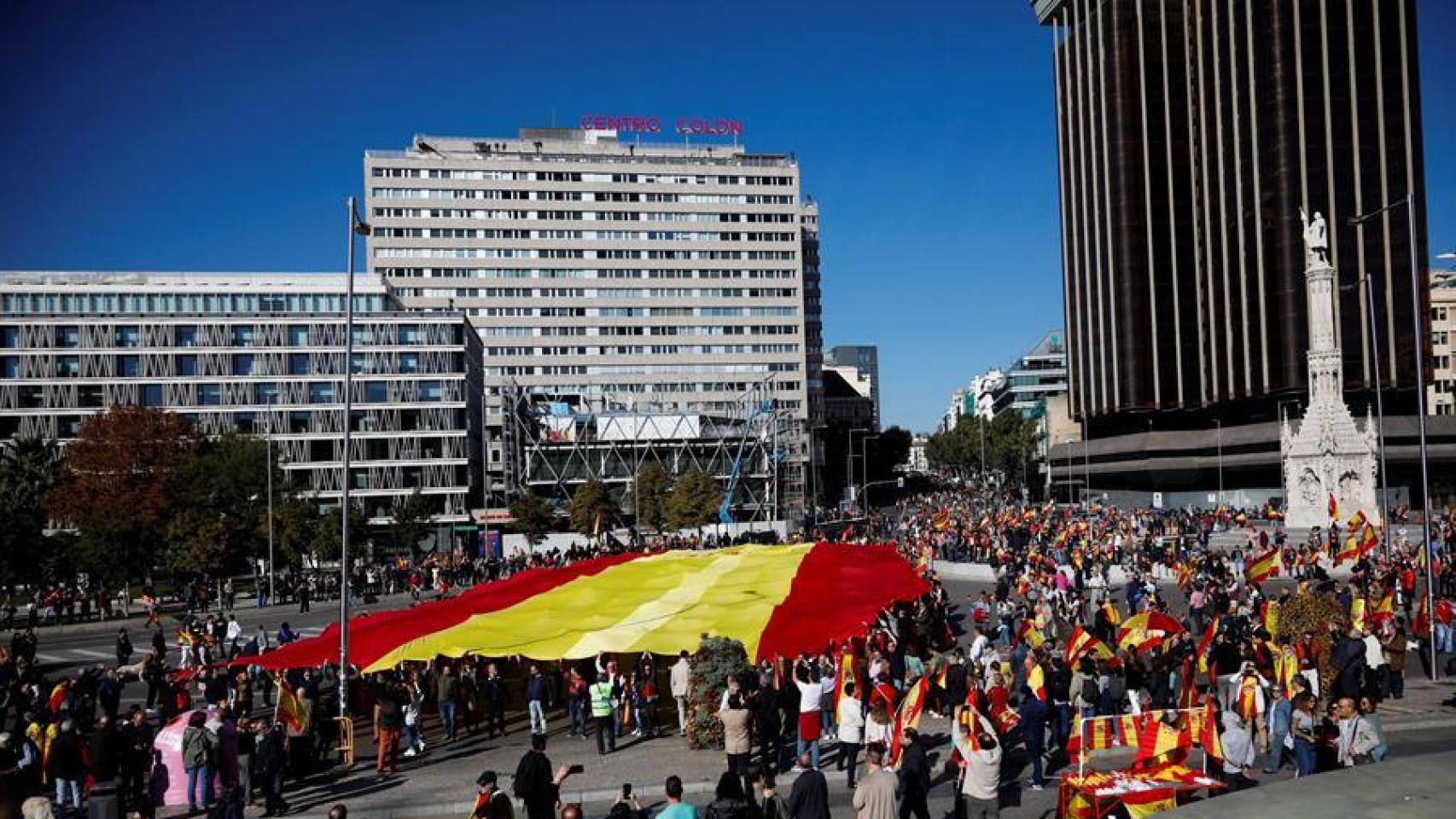 Una enorme bandera de España ha presidido la concentración de Vox en Colón.