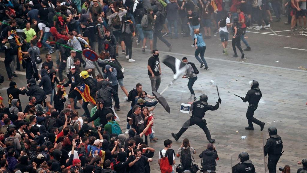 Mossos d'Esquadra ante manifestantes independentistas en el aeropuerto del Prat.