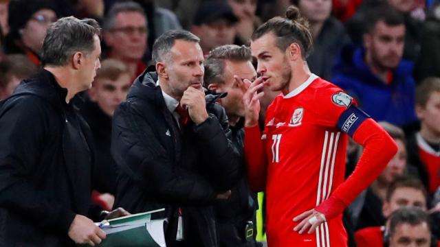 Ryan Giggs y Gareth Bale dialogan durante un partido de Gales