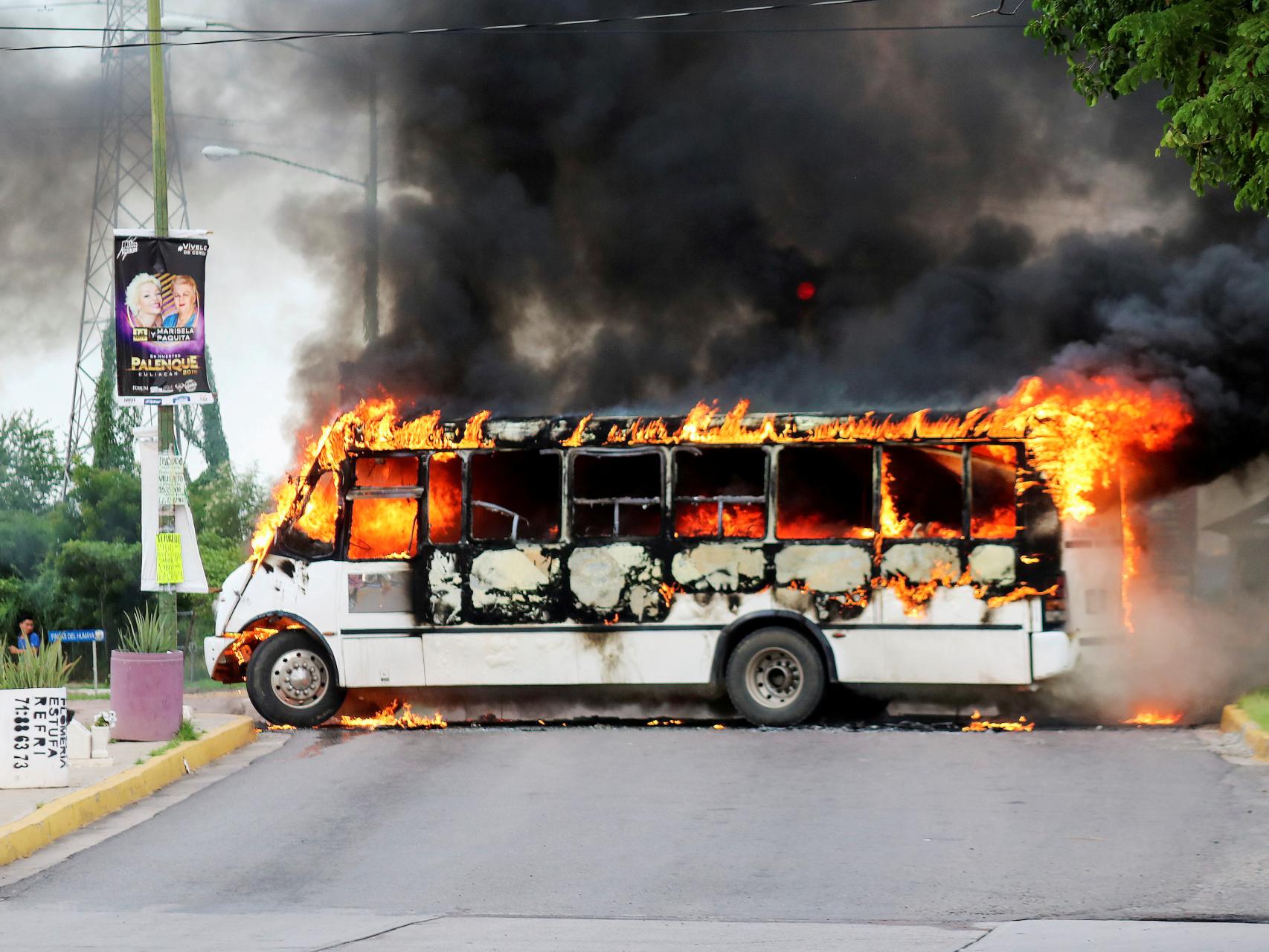 Un autobús ardiendo tras los enfrentamientos entre un cartel y la policía.