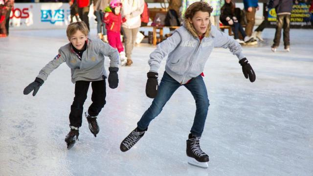 Dos niños en una pista de hielo.