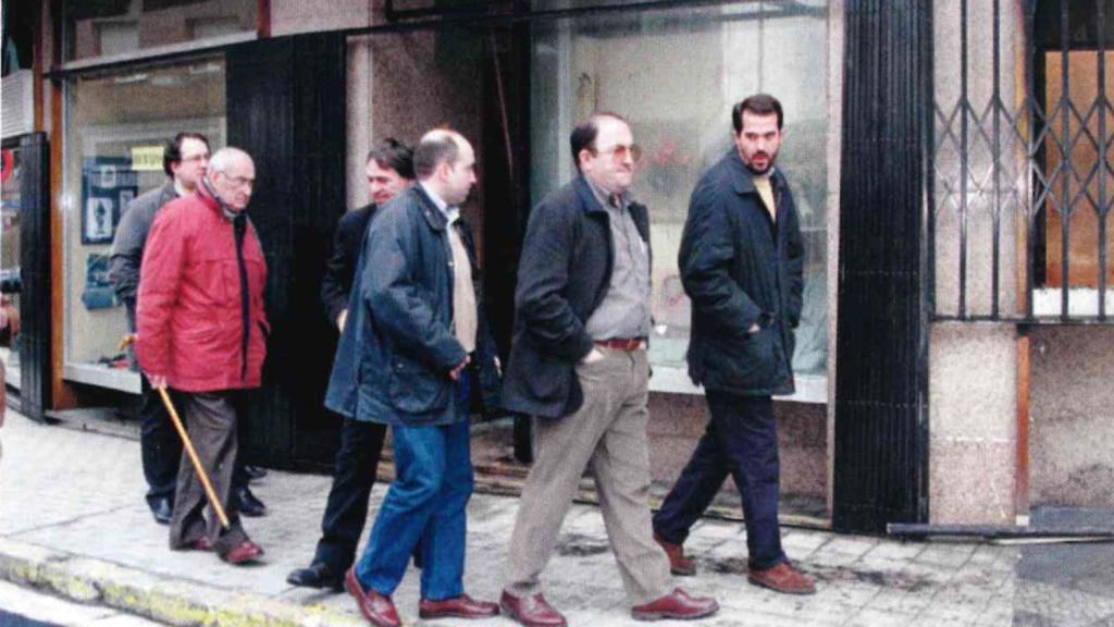 Manolo Abascal (con abrigo rojo) delante de su tienda, tras ser vandalizada.