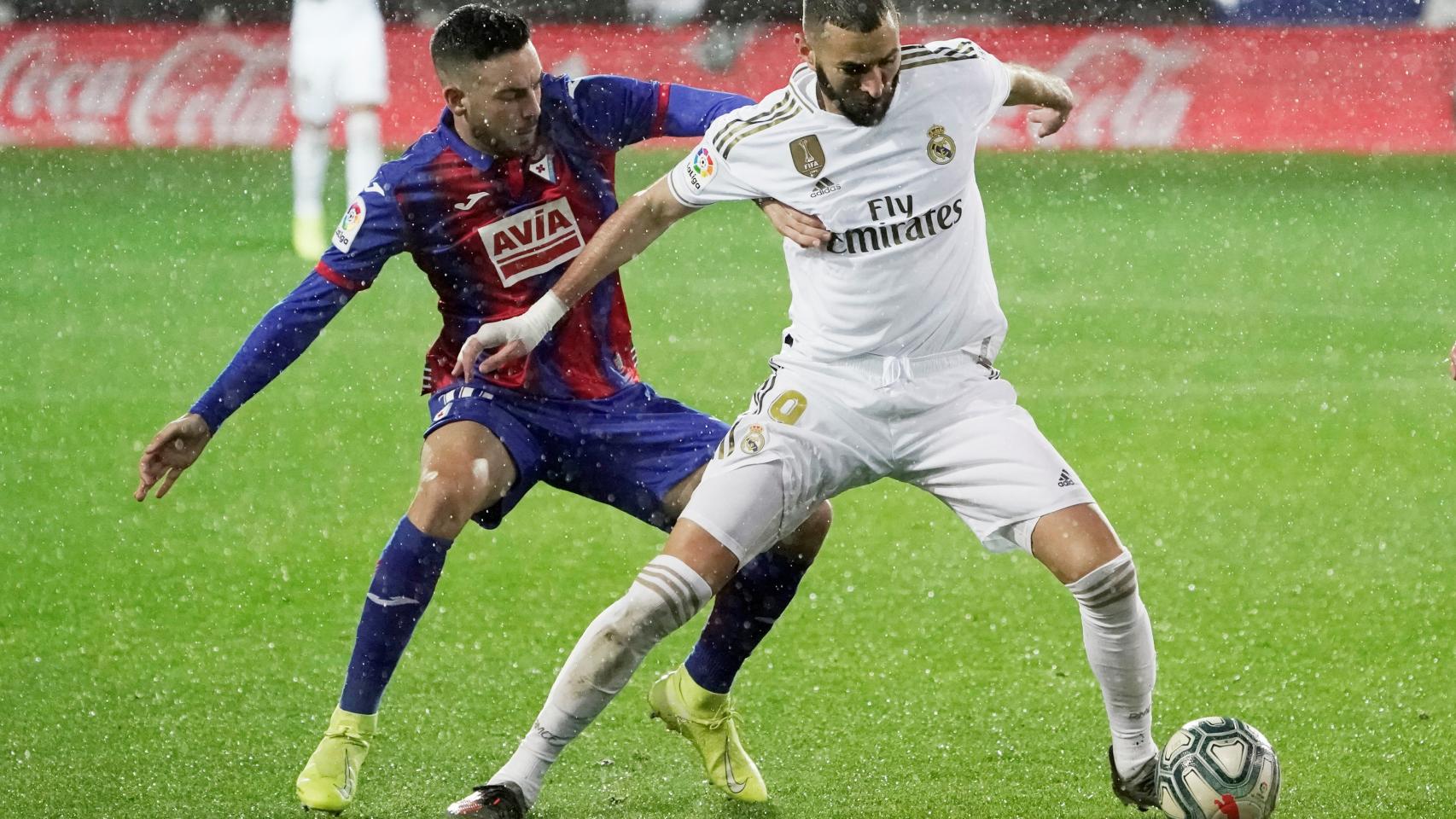 Karim Benzema defiende el balón de un jugador del Eibar