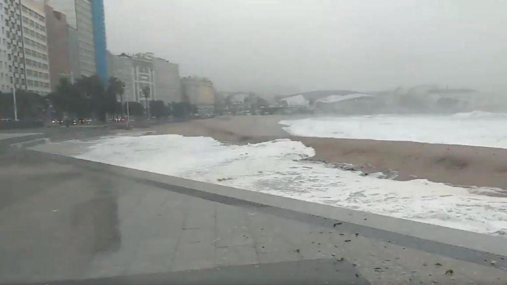 Las olas superan la duna de la playa de Riazor, en A Coruña