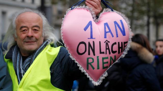 Un manifestante muestra un corazón que conmemora un año de los chalecos amarillos.