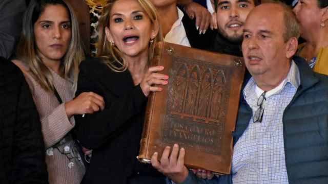 Jeanine Áñez tomando posesión con una Biblia gigante.