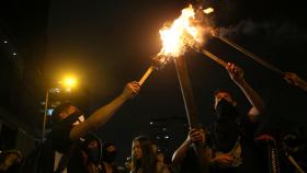 Manifestantes encienden antorchas durante una protesta en el Parque de los Hippies, en Bogotá.