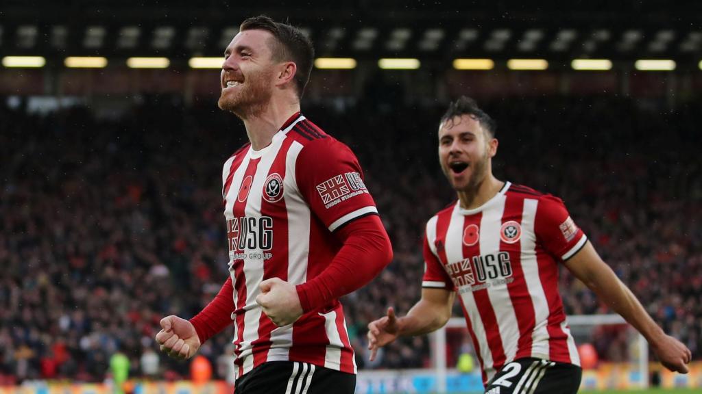 John Fleck, escocés, y George Baldock, inglés, celebran un gol