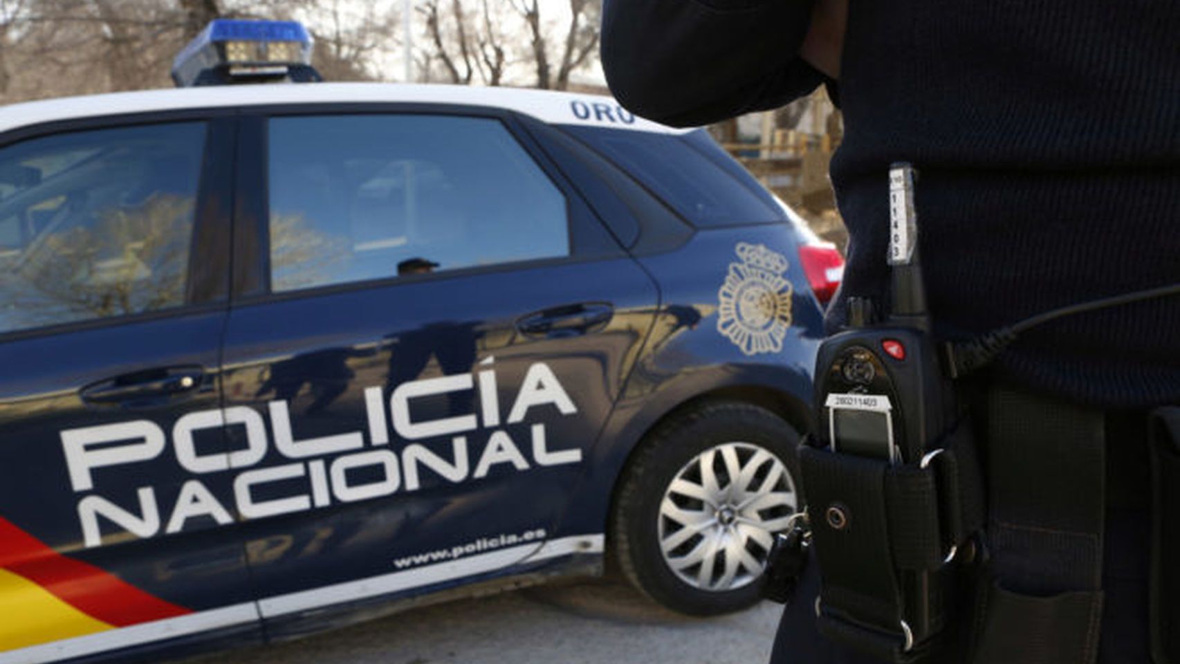 Imagen de archivo de un coche y un agente de la Policía Nacional.