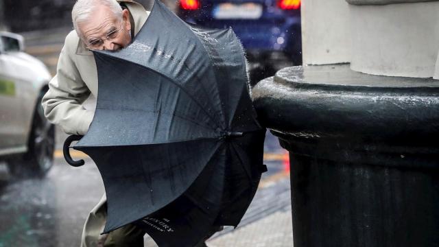 Un hombre trata de controlar su paraguas este sábado en San Sebastián. EFE/ Javier Etxezarreta.
