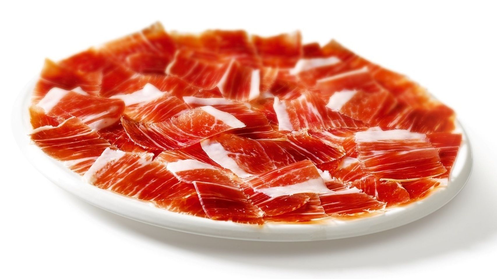 Un plato repleto de pequeñas lonchas de jamón ibérico.